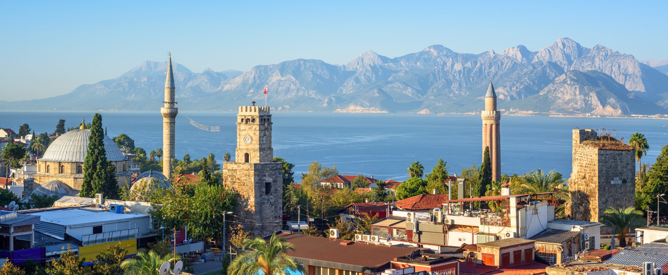 Panoramic view of Antalya Kaleici Old Town with the Clock Tower, Yivli Minaret, Tekeli Mehmet Pasa mosque, Mediterranean Sea and the Taurus Mountains in background, Turkey